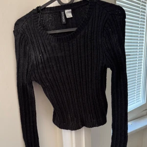 Svart ribbad tröja från H&M Divided - Säljer en svart ribbad tröja från H&M Divided. Tröjan har långa ärmar och är lite fläckig osäker om det går bort i tvätt. Perfekt för att lägga till lite glamour i vardagen. 🖤