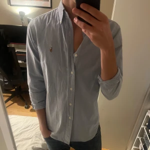 Blå skjorta från Ralph Lauren - Säljer en skit snygg skjorta från Ralph Lauren. Perfekt inför våren och sommaren! Den är i barnmodell, men passar medium och möjligen small. 
