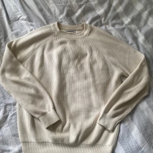 Beige tröja från Zara - Säljer en stilren beige tröja från Zara. Tröjan har en ribbad struktur och långa ärmar, perfekt för en avslappnad look. Passar bra till både jeans och chinos. Perfekt för alla årstider 