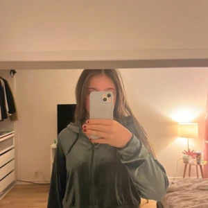 Grön velourjacka från Monki - Säljer en snygg grön velourjacka från Monki. Jackan har en dragkedja framtill och är långärmad. Perfekt för en avslappnad stil med en touch av lyx. Passar bra till både vardag och speciella tillfällen.