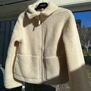 Eftertraktad teddyjacka - Mysig beige teddyjacka från H&M med dragkedja framtill. Jackan har en klassisk krage och två fickor. Jackan är aldrig använd! Storlek S men passar även en M. Tror inte den finns kvar att köpa💗
