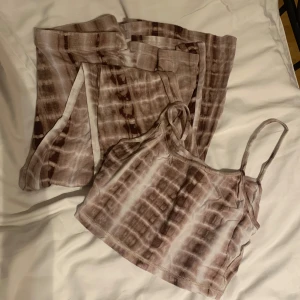 Brun- och vitmönstrad linnetopp utsvängda byxor sett  - Säljer en brun- och vitmönstrad linnetopp med smala axelband och matchande utsvängda byxor. Tyget är otroligt mjukt och skönt 