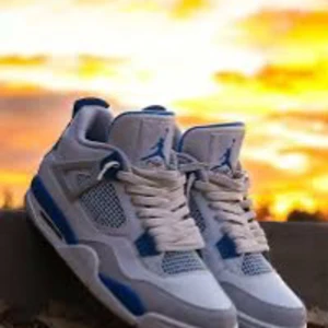 Nike Jordan 4 sneakers vit/blå - Säljer ett par Nike Jordan 4 sneakers i fräsch vit och blå färg med meshpaneler och snygga detaljer. Skorna har snörning, platt sula och den klassiska Jumpman-loggan på tungan. Perfekt för dig som vill ha en ikonisk och sportig look.
