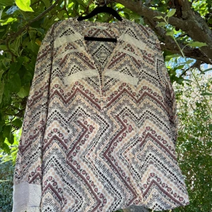 Odd Molly mönstrad långärmad skjorta - Supersnygg långärmad blus från Odd Molly med bohemiskt mönster i beige, vinrött och svart. Blusen har spetsdetaljer vid ärmslut och bröst, samt v-ringad hals. Tillverkad i mjuk bomull, perfekt för dig som gillar unika detaljer och coola prints. Storlek 4 som enligt deras storleksguide motsvarar en storlek L/XL, men jag tycker denna modell är liten i storlek.  Mycket fint skick, jag hittar inga synliga anmärkningar eller defekter.