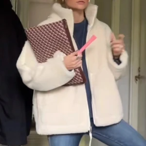 Beige teddyjacka - Mysig beige teddyjacka med dragkedja och hög krage. Perfekt för kyliga dagar och ger en trendig look. Jackan har en avslappnad passform och långa ärmar.