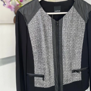 Svart och grå kavajjacka från Taifun - Snygg svart och grå kavajjacka från Taifun med coolt rutigt mönster framtill och bak. Jackan har lång ärm, dragkedja och detaljer i skinnimitation vid axlar och fickor. Perfekt för dig som gillar en stilren men edgy look.