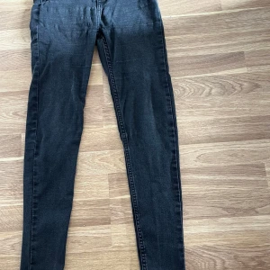 Svarta skinny jeans från 157, S - Svarta jeans från 157 i storlek S med smal passform och klassisk femficksdesign. Jeansen har en skinny siluett och är tillverkade i stretchigt jeansmaterial som sitter tajt längs benen. Perfekta för dig som gillar en stilren och enkel look.