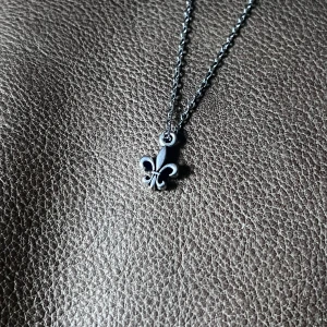 Minimalist Fleur de Lis Necklace - Stainless steel necklace with a subtle Fleur de Lis charm (approx. 1.3 cm). 50 cm chain. Sleek, unisex design for everyday elegance