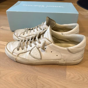 Philippe Model skor - Snygga vita sneakers från Philippe Model med klassisk låg profil och rund tå. De är i storlek 42. Mycket bra skick förutom defekterna under sulan. Allt og medföljer.