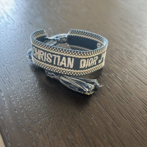 Blå Christian Dior Friendship Armband - Snyggt blått friendship armband från Christian Dior med vit broderad logga och detaljerade kanter. Armbanden är justerbart så de passar alla!den är ny och oanvänd,skriv gärna för frågor eller fler bilder!