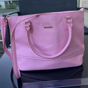 Rosa axelväska / bag - Superfin rosa väska. Den är i syntetmaterial och har en praktisk dragkedja upptill. Insidan är randig och har flera fack för bra organisering. Perfekt storlek för laptop, skolböcker mm. Hämtas på Hägerstensåsen eller ök. 🌸🩷🎀