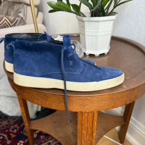 Blå mocka boots från Tod's - Snygga ökenkängpr från Tod's i mörkblå mocka med beige platt sula. Fick dessa av min tjej för några veckor sen men är tyvärr lite små och knappt använda 