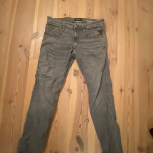  Replay Anbass grå jeans slim fit(trasiga) - Grå jeans från Replay, modell Anbass, ett hål imellan benen som är hyfsat stort men går nog å fixa om du eller nån annan är händig nog! Annars är allting fint med dom storlek 31/32
