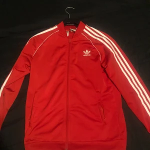 Röd Adidas tröja  - Säljer en röd Adidas tröja som bara är använd ett par gånger och är fortfarande i nytt skick, passar storlek S och XS. (Står i storlek 170)