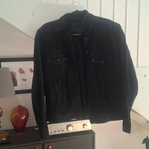 Svart jeansjacka från Levi's XS - Säljer en svart jeansjacka från Levi's Premium i storlek XS. Klassisk modell med knappar framtill, två bröstfickor med lock och Levi's röda logotagg. Jackan är i denim och har en snygg, tidlös look som passar till allt. Den ser liten ut på bilden men de är eftersom att den är för liten för mig. Innan jackan skickas iväg kommer den att tvättas om de önskas, jag har använt den några gånger men den är fortfarande I bra skick, pris kan diskuteras och är inte hugget i sten, hör gärna av er om intrese