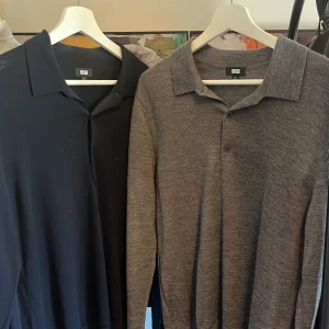 Marinblå och grå långärmad pikétröja Uniqlo - Två stilrena långärmade pikétröjor från Uniqlo, en i marinblå och en i melerad grå. Båda har klassisk krage och knappslå framtill. Materialet känns mjukt och lätt, perfekt för dig som gillar enkel och clean stil. Passar dig som vill ha en chill och snygg look. Aldrig använt någon av tröjorna för tyckte inte d passade min stil. Hör gärna av er om funderingar eller prisförslag