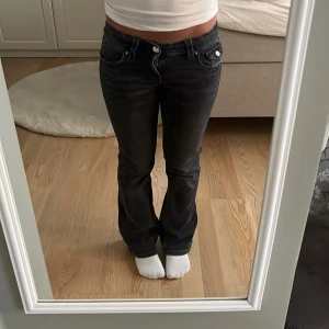 Svarta bootcut jeans från Gina Tricot - Säljer ett par svarta jeans från Gina Tricot i storlek 152. Modellen har bootcut-ben och låg midja, klassiska fem fickor med snygga detaljer och silverfärgade knappar. Jeansen är gjorda i jeansmaterial med en mörk tvätt och dragkedja framtill. Mått: 37 cm rakt över midjan (går och justera) ca 70 cm innerbenslängd 💗