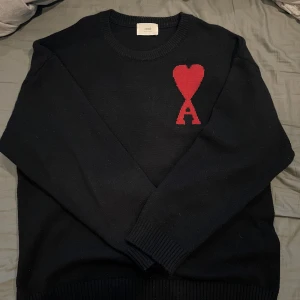 Svart stickad tröja med rött hjärta från ami - Säljer denna eftersom jag inte använder den, väldigt skön och varm speciellt mot höst och vintern. Storleken är S men den är större än vad man tror. Pris 1000kr 