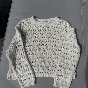 Vit virkad tröja från Stradivarius - Säljer en söt vit virkad tröja från Stradivarius i storlek M. Tröjan har ett hålmönster över hela och ribbade muddar vid ärmslut och nederkant. 
