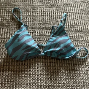 Blå bikini med tigermönster - Binini överdel, justerbara axelband. Aldrig använd