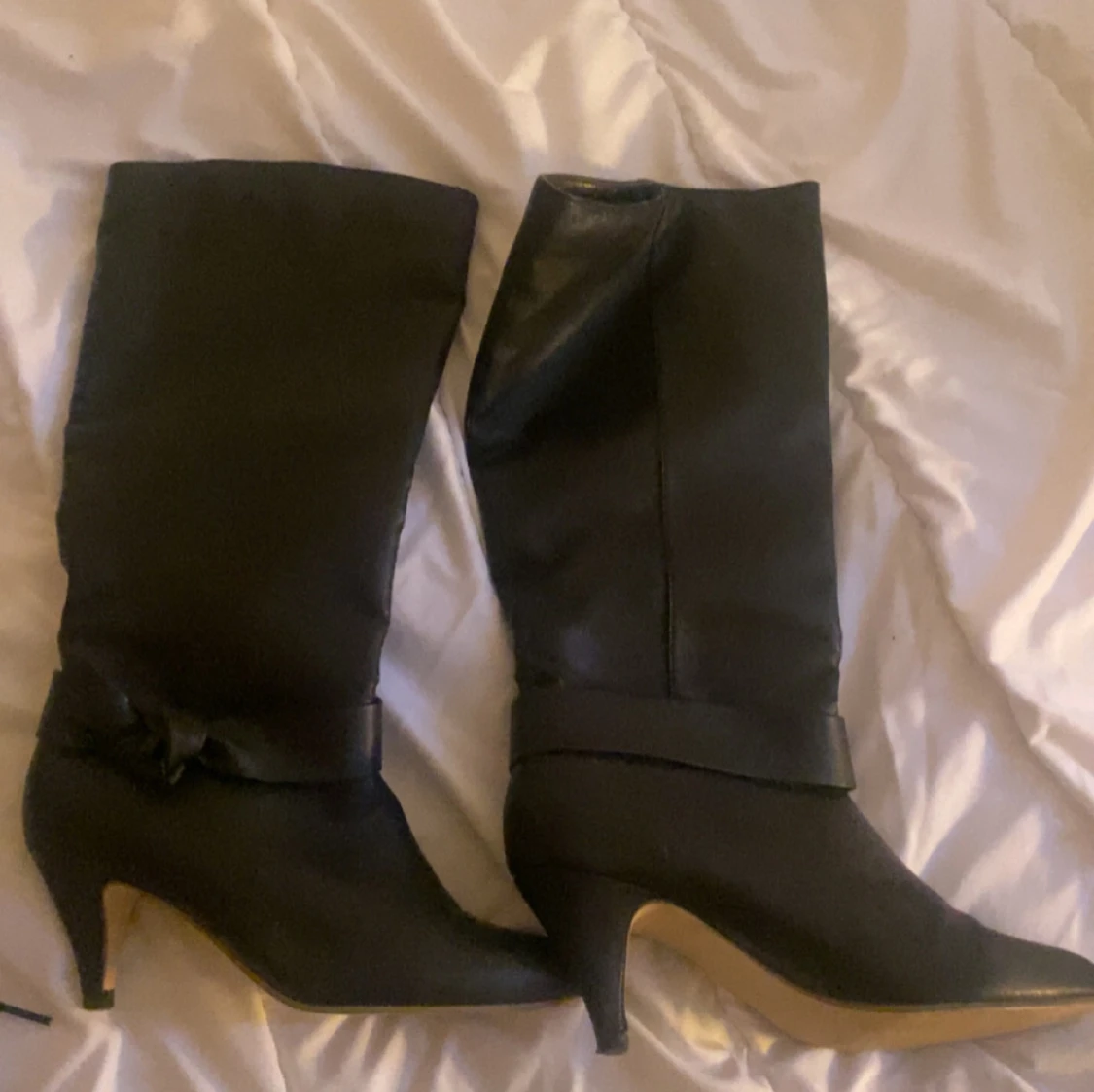 Svarta stövlar med klack och rosettdetalj