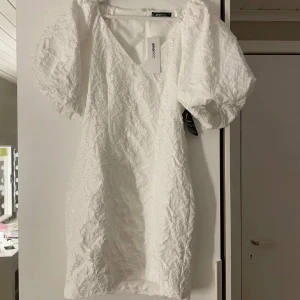 Studentklänning  - Säljer denna superfina brocade studentklänningen från ginatricot i storlek 34, slutsåld på hemsidan! Säljer endast då den tyvärr inte passade mig. Helt ny med prislapp kvar och endast testad på av mig och den jag köpte den av💕 Inte mina bilder!