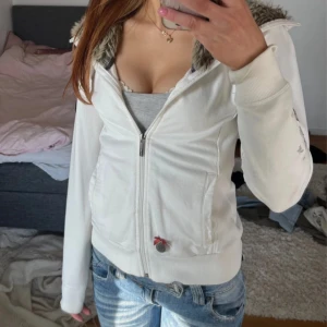Vit zip up med fuskpäls från HV Polo - pris går att diskutera!!Vit hoodie med dragkedja och fuskpäls på från HV Polo. Broderad logga på ryggen och patch på ärmen. Har en liten fläck på armen! Storlek S! Lånade bilder!! Skriv för egna! Ser ut som en luva men de ingen påriktigt