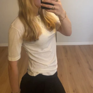 Vit t-shirt med knappar från Lindex - Säljer en klassisk vit t-shirt från Lindex i storlek S och knappar framtill vid halsen. Mjukt material med bra passform. Perfekt basplagg till garderoben, säljer för att den inte kommer till användning💗