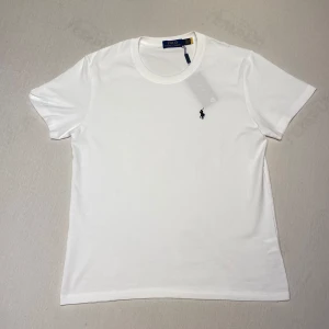 Polo Ralph Lauren t-shirt  - Polo Ralph Lauren t-shirt i ny skick, inga defekter. Perfekt för sommaren, snygg vit färg och ganska tunn. Loggan skannar, och den kommer i påsen jag fick den med. Säljer då den inte passar mig. 