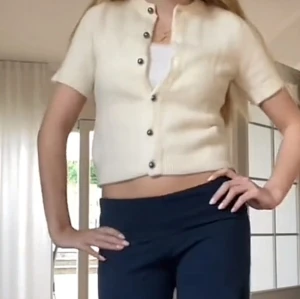 Vit kortärmad kofta från Ginatricot - Säljer en söt vit kofta från Ginatricot med korta ärmar och knappar framtill. Koftan är stickad och har en mjuk känsla, perfekt att slänga över en topp. Enkel och stilren design som passar till mycket.