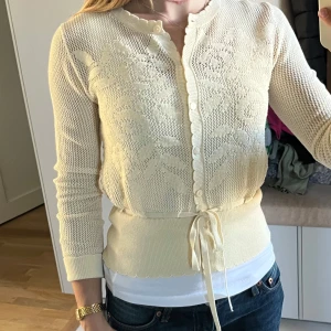 Krämvit spetskofta med knytband - Helt ny utan prislapp därav det höga priset. Ordinariepris: 379kr. Sval och skön till sommaren och har ett band i midjan som kan knytas. Super gulligt🩷