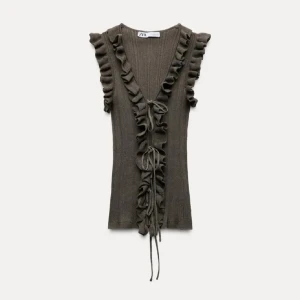 Olivgrön ribbad topp med volang från Zara - Supersnygg olivgrön ribbad topp från Zara med volangdetaljer längs v-ringningen och axlarna.💕