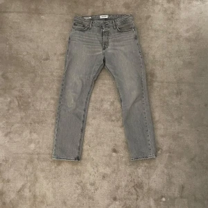 Grå jeans Jack & Jones - Säljer ett par grå jeans från Jack & Jones.    Loose/Chris med klassisk femficksdesign och raka ben. Jeansen har normal passform och är tillverkade i denim med en snygg tvättad look. Perfekta för dig som gillar en avslappnad stil.