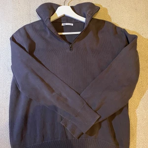 Grå Half Zip från Zara - Säljer en mörkgrå långärmad tröja från Zara med halv dragkedja och hög krage. Passar dig som letar efter en klassisk old money stil. 