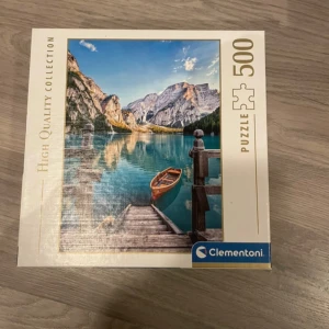Clementoni pussel 500 bitar - Sjölandskap - Säljer ett Clementoni pussel med 500 bitar från High Quality Collection. Motivet är ett vackert sjölandskap med berg, en brygga och en röd roddbåt. Perfekt för dig som gillar naturmotiv och pusselutmaningar.