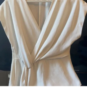 vit knyt tröja - Säljer en elegant vit tröja med          v-ringning och knyt i midjan, stilren och passar till allt. Perfekt för dig som vill ha en enkel men snygg look.  !! INTE MINA BILDER !!