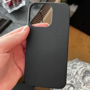 Svart mobilskal iPhone 13 Pro - Säljer ett stilrent svart mobilskal med matt finish. Skalets design är enkel och passar perfekt till dig som vill ha ett diskret skydd till mobilen. Öppning för kamera och knappar. Perfekt för att skydda din telefon mot repor och stötar. 