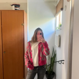 Rosa och grå kofta från Stories - Cool och unik kofta från Stories i storlek S. Koftan är i rosa och grått zebra mönster och perfekt för att liva upp garderoben med lite färg!