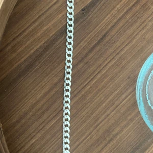 Silver armband (925) pansarlänk - Stilrent armband i silverfärg med kraftiga länkar och karbinlås. Märkt med 925 vilket indikerar äkta silver. Perfekt för dig som gillar klassiska smycken med lite tyngd. Kan mötas upp i Göteborg eller fraktas. Väger 20.7 och 22cm längd och 8mm bredd. Säljes pga jag har andra smycket jag använder. Den är köpt för drygt 2000kr så priset är fast