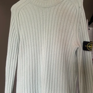 Ljusgrön stickad tröja från Stone Island - Säljer en ribbstickad ljusgrön tröja från Stone Island med klassisk patch på ärmen. Använd men har mycket kvar att ge 🙌. Priset är inte hugget i sten.