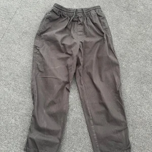 Svarta surf pants från Polar Skate Co - Svarta byxor från Polar Skate Co med elastisk midja och dragsko. Byxorna har en avslappnad passform. Perfekta för en chill och avslappnad stil. Byxorna har inte använts så mycket