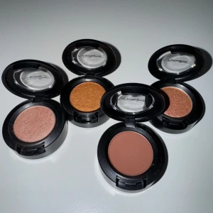 MAC ögonskuggor i varma nyanser - Fyra singelögonskuggor från MAC i olika varma nyanser: koppar, brons, roséguld och matt brun. Singel eye shadow's följande namn:  . All that glitters  . Tutu good  . Jingle ball bronze  . Swiss chocolate