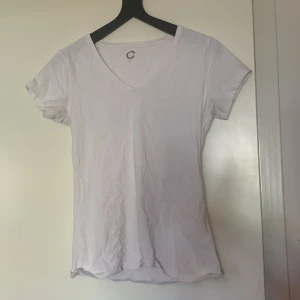 Vit v-ringad t-shirt från Cubus - En klassisk vit t-shirt från Cubus med v-ringning och korta ärmar. Tillverkad i mjuk bomull, perfekt för en enkel och stilren look. Passar dig som gillar basic-plagg med skön passform.