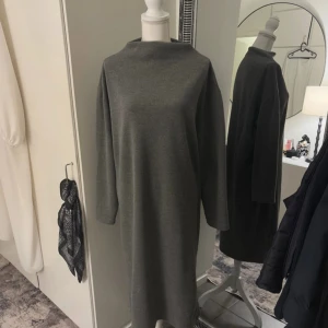 Mörk grå klänning  - Helt ny aldrig använt, fast pris    •Går under knäna på mig •väldigt varm för vintern och kallare dagar • Jag är normal storlek S/M i kläder men vill ha det lite lösare därav stolek L.  •aldrig använd ute, endast testad på bild  - Inga bud, köp direkt för det priset!🥰