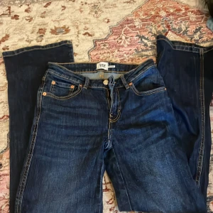 Mörkblå jeans från 157 med raka ben - Snygga mörkblå jeans från 157 med raka ben och klassiska kontrastsömmar. Jeansen har fem fickor, varav bakfickorna har lock och knapp. Tillverkade i slitstarkt denim med normal passform och midja.