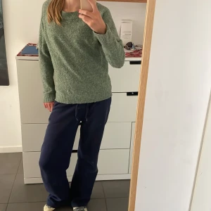Grön stickad tröja från Vero Moda - Mysig grön stickad tröja från Vero Moda i storlek XS. Tröjan har en klassisk rund halsringning, långa ärmar och ribbade muddar vid ärmslut och nederkant. Perfekt för lager-på-lager och chill dagar. 