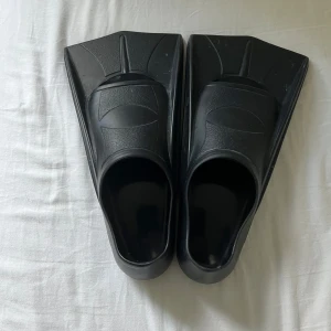 Svarta simfenor i gummi, stl 33-34 - Svarta simfenor i mjukt gummi, perfekta för bad och simträning. De har en klassisk, bred form och är enkla att ta på och av. Storlek 33-34 EU, passar dig som vill ha extra skjuts i vattnet. Säljs i par.