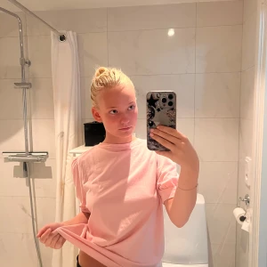 Ljusrosa t-shirt med puffärm - Säljer en ljusrosa t-shirt med puffiga korta ärmar och rund halsringning. T-shirten har en loose passform och är tillverkad i mjuk bomull, perfekt för en chill och avslappnad stil.