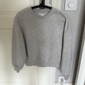 Grå sweatshirt från Gina Tricot - Enkel och stilren ljusgrå sweatshirt från Gina Tricot med rund halsringning och ribbade muddar. Tröjan har en loose passform och är tillverkad i mjuk bomullsmix, perfekt för chill dagar eller när du vill ha en clean look.🤍