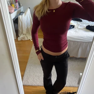 Vinröd långärmad tröja - Säljer en vinröd långärmad tröja med tight passform. Tröjan har rund halsringning och är tillverkad i ett mjukt, stretchigt material som sitter snyggt på kroppen. Perfekt för dig som gillar stilrena basplagg med en djup färg. knappt använd!💕💕